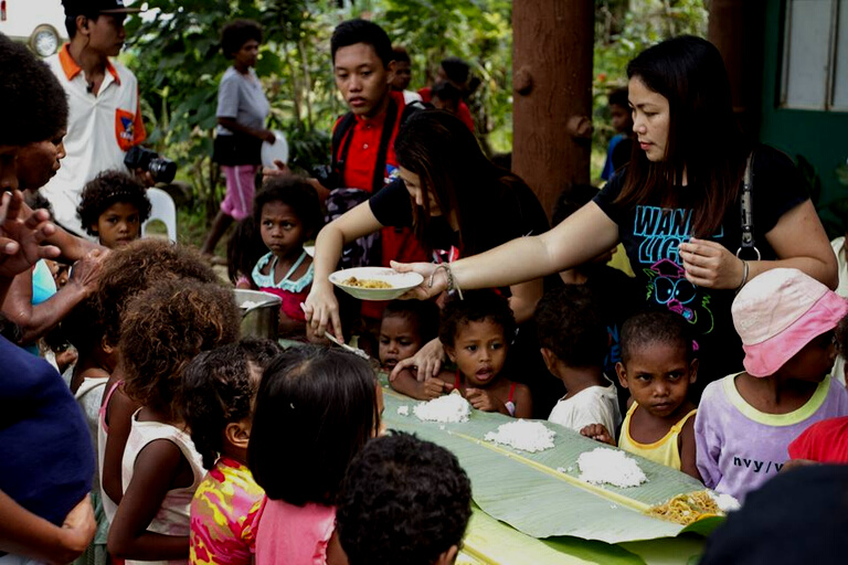 People Feeding Kids in an Outreach Program 